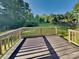 Inviting backyard deck made of dark composite and wood railings overlooking the green, spacious backyard at 15003 Boudins Ln, Charlotte, NC 28278