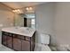 Bathroom vanity features dual sinks, dark wood cabinets, and bright lighting at 15003 Boudins Ln, Charlotte, NC 28278