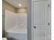 Bright bathroom featuring a tub with tiled walls and a convenient storage niche for bath essentials at 15003 Boudins Ln, Charlotte, NC 28278