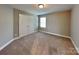 Carpeted bedroom with a window and a closet with double doors at 15003 Boudins Ln, Charlotte, NC 28278