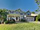 Inviting two-story home boasts a well-manicured lawn, charming front porch, and attached two-car garage at 15003 Boudins Ln, Charlotte, NC 28278