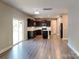 Open kitchen and dining area with stainless steel appliances, dark cabinets, and sleek, easy-to-clean floors at 15003 Boudins Ln, Charlotte, NC 28278
