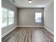 Inviting living room featuring sleek flooring, neutral paint, and natural light from two bright windows at 15003 Boudins Ln, Charlotte, NC 28278