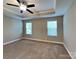 Spacious primary bedroom with ceiling fan, neutral walls and carpet, and two bright windows at 15003 Boudins Ln, Charlotte, NC 28278