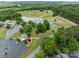 Aerial view of community featuring a pond with a fountain, trees, and a parking lot at 165 Cardinal Dr # 615, New London, NC 27371