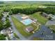 Aerial view of community amenities including a pool, tennis courts, playground, and parking at 165 Cardinal Dr # 615, New London, NC 27371