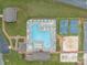 Aerial view of community pool, tennis courts, volleyball court, and playground surrounded by well-maintained landscaping at 165 Cardinal Dr # 615, New London, NC 27371