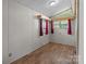Bedroom featuring neutral walls, wood-look flooring, and window with blinds and mauve curtains at 165 Cardinal Dr # 615, New London, NC 27371