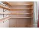 A closet interior featuring multiple bare wood shelves and a window with blinds at 165 Cardinal Dr # 615, New London, NC 27371