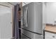 Modern stainless steel refrigerator with a door to the outside, adjacent to shelving and countertop at 165 Cardinal Dr # 615, New London, NC 27371