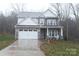 Charming two-story home featuring stone accents, a two-car garage, and a well-manicured front lawn at 1727 Grace Ln, Charlotte, NC 28262