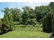 Serene backyard with lush greenery, a well-maintained lawn, and a black metal fence at 1809 Evergreen Dr, Charlotte, NC 28208