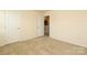 Bright bedroom with neutral walls, carpeted floor, and doors to closet and another room at 1809 Evergreen Dr, Charlotte, NC 28208