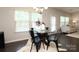 Bright dining area features modern chandelier, glass-top table, and dark hardwood floors at 1809 Evergreen Dr, Charlotte, NC 28208