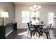 Elegant dining area featuring hardwood floors, a modern chandelier, and ample natural light from large windows at 1809 Evergreen Dr, Charlotte, NC 28208