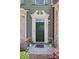 Elegant entryway with a dark green door, decorative molding, stylish lighting, and a welcoming floral rug at 1809 Evergreen Dr, Charlotte, NC 28208