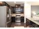 Modern kitchen featuring stainless steel appliances, dark cabinetry, granite countertops, and hardwood flooring at 1809 Evergreen Dr, Charlotte, NC 28208