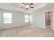Main bedroom with tray ceiling, ceiling fan, and attached bathroom with glass shower at 1809 Evergreen Dr, Charlotte, NC 28208