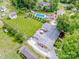 Aerial view showcasing the house, well-manicured lawn, pool, outbuildings, and mature trees at 195 Brookfield Cir, Mooresville, NC 28115