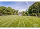 Expansive backyard with a manicured lawn, shed, and mature trees, offering privacy at 195 Brookfield Cir, Mooresville, NC 28115