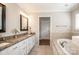 Bathroom featuring a soaking tub, granite counters, double vanity and white cabinets at 195 Brookfield Cir, Mooresville, NC 28115