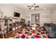 Cozy playroom featuring a ceiling fan, wood floors, comfortable seating, and organized storage shelves at 195 Brookfield Cir, Mooresville, NC 28115