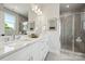 Luxury bathroom featuring double sinks, a large mirror, marble countertops, and a glass shower at 2009 Clarksdale Dr # 39, Charlotte, NC 28206