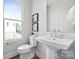 Bright white bathroom featuring a pedestal sink, modern fixtures, and a window with a view at 2009 Clarksdale Dr # 39, Charlotte, NC 28206