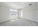 Bright, neutral bedroom features plush carpet, an adjacent outdoor deck, and ample natural light at 2009 Clarksdale Dr # 39, Charlotte, NC 28206
