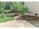 Backyard showcasing a well-maintained lawn, wooden fence, and landscaped flowerbeds at 212 Forest Walk Way, Mooresville, NC 28115