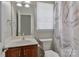 This is a light and bright bathroom featuring a toilet, vanity and a shower with a marble patterned curtain at 212 Forest Walk Way, Mooresville, NC 28115