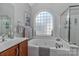 Bright bathroom featuring a jacuzzi tub with clear window and artwork displayed at 212 Forest Walk Way, Mooresville, NC 28115