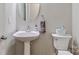 Powder room featuring pedestal sink, round mirror, white fixtures, and neutral decor at 212 Forest Walk Way, Mooresville, NC 28115