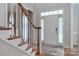 Bright foyer featuring a staircase with wooden handrail and a view of the front door at 212 Forest Walk Way, Mooresville, NC 28115
