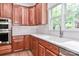 This kitchen features a stainless steel sink, cherry cabinets, and a large window to the backyard at 212 Forest Walk Way, Mooresville, NC 28115