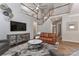 Open-concept living area featuring a modern staircase, comfortable leather seating, and stylish decor at 212 Forest Walk Way, Mooresville, NC 28115
