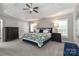A spacious main bedroom with a tray ceiling, ceiling fan, and dark wood furniture exudes comfort and elegance at 212 Forest Walk Way, Mooresville, NC 28115
