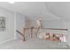 This is the second story landing that leads to the staircase featuring neutral colors, carpet and wooden handrails at 212 Forest Walk Way, Mooresville, NC 28115