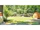 Shady backyard with a shed and swing set offers a tranquil outdoor space at 217 Eighth Ave, New London, NC 28127