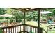 A lush backyard with seating, an umbrella, and a swing set is perfect for relaxing at 217 Eighth Ave, New London, NC 28127