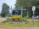 Pinchaven Village entrance sign surrounded by beautiful landscaping and flowerbeds at 217 Eighth Ave, New London, NC 28127