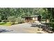 View of the house featuring a gravel driveway, well-kept landscaping, and wooded surroundings at 217 Eighth Ave, New London, NC 28127