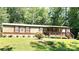 View of the home's well-maintained exterior, featuring brown shutters and a cozy front porch at 217 Eighth Ave, New London, NC 28127