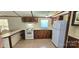 This eat-in kitchen features white appliances, warm wood cabinets and tile flooring at 217 Eighth Ave, New London, NC 28127