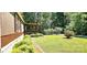 Lush green lawn and mature landscaping with a covered porch at 217 Eighth Ave, New London, NC 28127