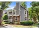 Charming condo featuring a brick facade, neutral siding, lush landscaping, and multi-level balconies at 2502 Cranbrook Ln # 8, Charlotte, NC 28207