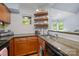 Bright kitchen showcasing floating shelves, granite countertops, and stainless steel sink at 2502 Cranbrook Ln # 8, Charlotte, NC 28207