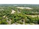Expansive aerial view showing a large wooded lot with mature trees and proximity to a pond at 2601 Greenmont Cir, Belmont, NC 28012