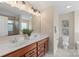 Modern bathroom with double sinks, wood cabinets, large mirrors, and bright lighting for a luxurious feel at 3211 Gilroy Dr, Fort Mill, SC 29707