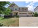 Charming two-story home features a three-car garage, manicured lawn, and inviting curb appeal at 3211 Gilroy Dr, Fort Mill, SC 29707